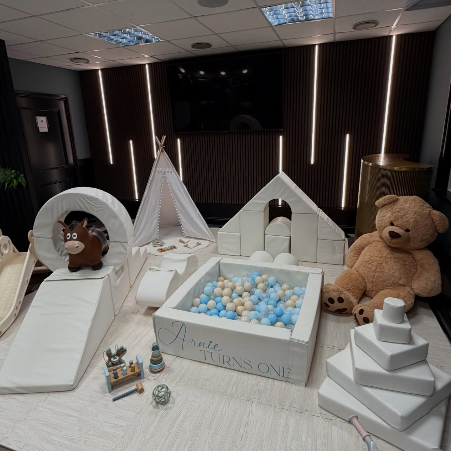 Arnie Turns One neutral blue soft play setup with ball pit and teddy bear
