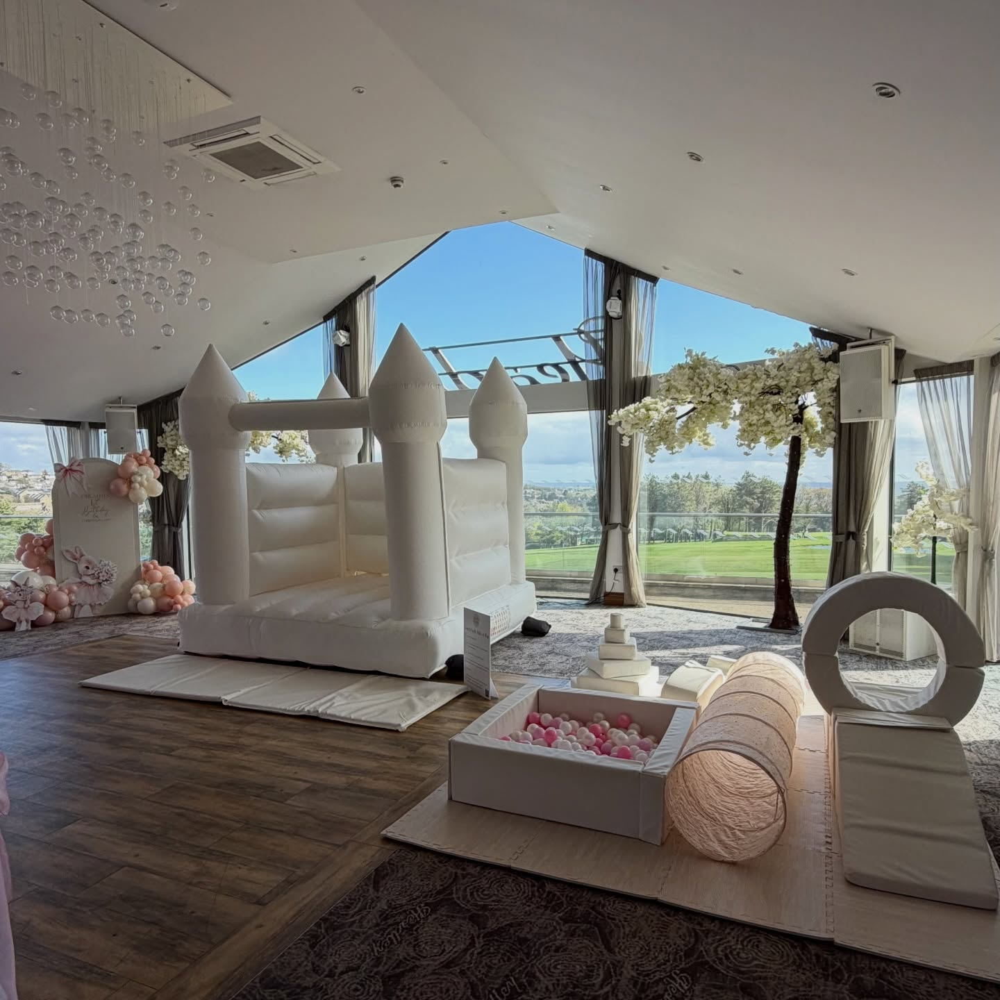White bouncy castle with pink ball pit and soft play at a luxury venue
